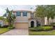 Two-story house with beige exterior, tan garage door, and landscaping at 12088 Uleta Ln, Orlando, FL 32827