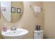 Small powder room with pedestal sink and oval mirror at 12088 Uleta Ln, Orlando, FL 32827