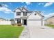 Two-story house with gray exterior, two-car garage, and landscaped lawn at 131 Cambria Grove Cir, Davenport, FL 33837