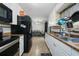 Long kitchen with white cabinets, tile floor, and black appliances at 1404 Adair St, Ocoee, FL 34761