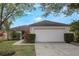 Single-story house with a white garage door and well-maintained lawn at 14528 Lycastle Cir, Orlando, FL 32826