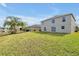 View of the house from the large backyard, with lawn and pond at 1633 Corner Meadow Cir, Orlando, FL 32820
