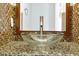 Stylish bathroom vanity with a clear glass bowl sink, decorative mirror, and tiled backsplash at 1633 Corner Meadow Cir, Orlando, FL 32820