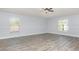 Bright bedroom features modern gray wood-look flooring and neutral paint, illuminated by natural light through two large windows at 1633 Corner Meadow Cir, Orlando, FL 32820