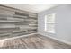 Bedroom with gray plank accent wall and light gray laminate wood flooring at 1633 Corner Meadow Cir, Orlando, FL 32820