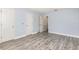 Neutral room with wood-look floors, neutral paint, white doors, and an open doorway at 1633 Corner Meadow Cir, Orlando, FL 32820