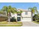 Two-story house with a green door, attached garage, and palm trees at 1633 Corner Meadow Cir, Orlando, FL 32820