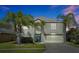Two-story house with a green door, attached garage, and palm trees at 1633 Corner Meadow Cir, Orlando, FL 32820