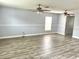 Spacious living room with two ceiling fans, light gray walls, white trim, and gray plank flooring at 1633 Corner Meadow Cir, Orlando, FL 32820