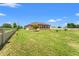 Backyard featuring a lush lawn with young trees under a clear blue sky at 1719 North W Blvd, Davenport, FL 33837