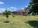 Backyard showing home, lush lawn, and young trees under a partially cloudy sky at 1719 North W Blvd, Davenport, FL 33837