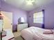 This purple themed bedroom has a ceiling fan, a dresser, and a window at 1719 North W Blvd, Davenport, FL 33837