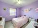 This is a purple bedroom with a window and decor on the walls at 1719 North W Blvd, Davenport, FL 33837