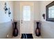Home entry featuring a white door, tile flooring, and decorative vases at 1719 North W Blvd, Davenport, FL 33837