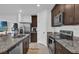 Modern kitchen with dark cabinets, granite countertops, and stainless steel appliances at 2058 Crape Jasmine Ln, Orlando, FL 32824