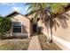 House entrance with walkway, palm tree, and tan walls at 2463 Hybrid Dr, Kissimmee, FL 34758