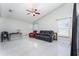 Spacious living room with tile floors, a black reclining sofa, and a red recliner at 2463 Hybrid Dr, Kissimmee, FL 34758