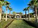 Community clubhouse entrance with palm trees and landscaping at 2516 Nouveau Way, Kissimmee, FL 34741