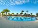 Large community pool with surrounding lounge chairs at 2516 Nouveau Way, Kissimmee, FL 34741