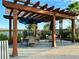 Seating area with a wooden pergola offering shade and a lake view at 2516 Nouveau Way, Kissimmee, FL 34741