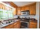 Kitchen with wood cabinets, granite counters, and stainless steel appliances at 277 Debary Dr, Debary, FL 32713