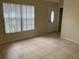 Living room with tiled floors, neutral walls, and a large window with blinds at 2852 India Blvd, Deltona, FL 32738