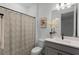 Modern bathroom with gray vanity, shower/tub combo, and patterned curtain at 4558 Lions Gate Ave, Clermont, FL 34711