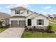 Two-story home with gray siding, two-car garage, and landscaped yard at 4558 Lions Gate Ave, Clermont, FL 34711