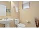 Clean bathroom with pedestal sink, toilet and window at 5120 Adelaide Dr, Kissimmee, FL 34746