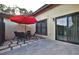 Private patio with red umbrella, table and chairs, and grey tile flooring at 532 Hunter Cir, Kissimmee, FL 34758