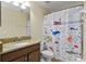 Bathroom featuring granite countertops, a mirror and a fun, nautical-themed shower curtain at 6124 Cypress Hill Rd, Winter Garden, FL 34787