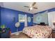 Blue bedroom with a ceiling fan, double bed, and dresser at 716 Katherine St, South Daytona, FL 32119