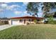 Ranch style home with a red roof and a well-maintained lawn at 716 Katherine St, South Daytona, FL 32119