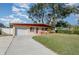 Ranch home with a white garage door and a long driveway at 716 Katherine St, South Daytona, FL 32119
