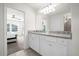 Bathroom with double vanity, granite countertop, and view of bedroom at 7260 Oakmoss Loop, Davenport, FL 33837