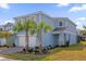 Two-story light blue house with a white two-car garage at 7260 Oakmoss Loop, Davenport, FL 33837