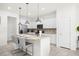 Kitchen with white cabinets, granite island, and stainless steel appliances at 7260 Oakmoss Loop, Davenport, FL 33837