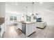 Open concept kitchen features an island, stainless steel appliances, and granite countertops at 7260 Oakmoss Loop, Davenport, FL 33837
