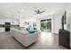 Open living room and kitchen with large sectional sofa at 7260 Oakmoss Loop, Davenport, FL 33837