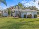 Gray house with palm trees, manicured lawn, and American flag at 843 Hammocks Dr, Ocoee, FL 34761