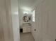 Bright, small bathroom with a single sink vanity, round mirror, and a window at 8634 Danforth Dr, Windermere, FL 34786