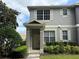 Charming two-story townhouse with covered entrance, lush landscaping, and neutral gray tones at 8634 Danforth Dr, Windermere, FL 34786