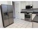 Modern kitchen features stainless steel appliances, white cabinets, and neutral tile flooring at 8634 Danforth Dr, Windermere, FL 34786
