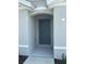 Exterior of home featuring a covered front entryway with a gray front door at 8864 Sw 49Th Cir, Ocala, FL 34476