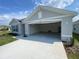 Open two-car garage with a freshly painted floor and driveway leading to the street at 8864 Sw 49Th Cir, Ocala, FL 34476