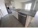 A kitchen island features stainless steel appliances, granite countertops and white cabinets at 8864 Sw 49Th Cir, Ocala, FL 34476