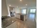 Open kitchen features island with sink, stainless steel appliances, and granite countertops at 8864 Sw 49Th Cir, Ocala, FL 34476