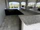Outdoor kitchen with a granite countertop bar, sleek cabinetry, and outdoor sink at 8864 Sw 49Th Cir, Ocala, FL 34476