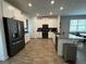 Modern kitchen with sleek, black stainless steel appliances, white cabinetry, and a kitchen island at 9741 Petition Way, Orlando, FL 32832