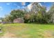 Lush backyard featuring a storage shed, above ground pool, and mature trees at 9877 7Th Ave, Orlando, FL 32824